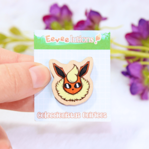 Pin de madera con diseño de la cara de Flareon, en su packaging.