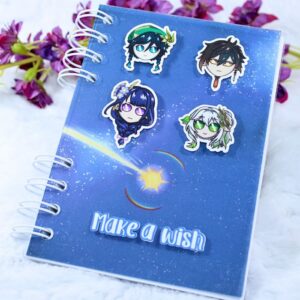 Cuaderno A6 con portada inspirada en Genshin Impact y la frase "Make a wish" en relieve. Puedes elegir hasta cuatro personajes en relieve a tu gusto para la portada.