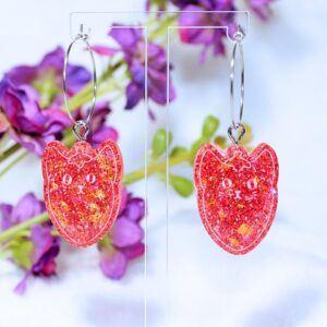 Pendientes de aro de color plateado con pieza de resina en color rojo, con forma de fresigato (fusión entre fresa y gato).