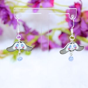 Pendientes de gancho de plata inspirados en Cinnamoroll, personaje de Sanrio, con abalorio en color azul brillante colgando.